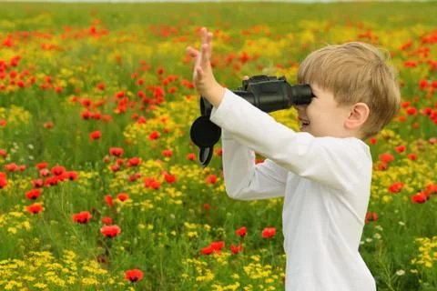 Boy in a field with binoculars Stock Photos