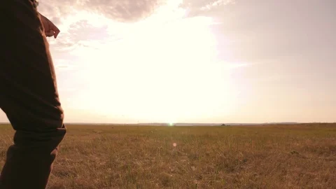 A boy in the field at sunset runs and throws a paper plane. The concept of a Stock-Footage 94754161