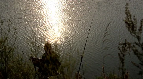 Little Boy is Casting Fishing Rod From Lake Shore Catching Fish in