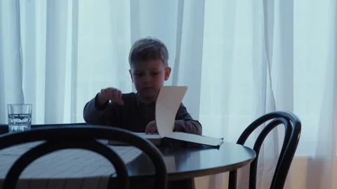 The boy flips through the pages of the book. Stock Footage 242142721