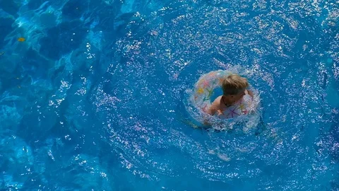 Boy floating on an inflatable circle in the pool, slow motion video Stock Footage 95884279