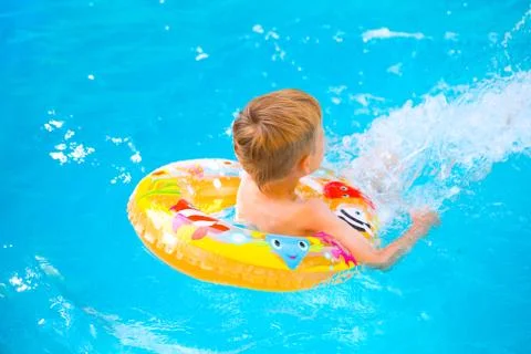 Boy floating on an inflatable circle in the pool Stockfoto's