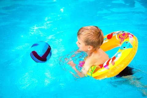 Boy floating on an inflatable circle in the pool Stock Photos
