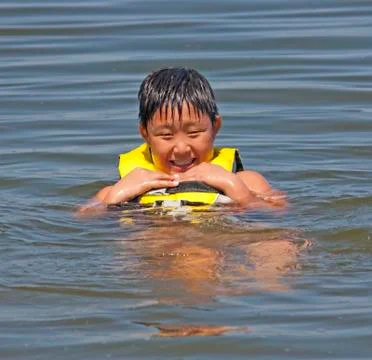 Boy floating in a life jacket Fotos de archivo