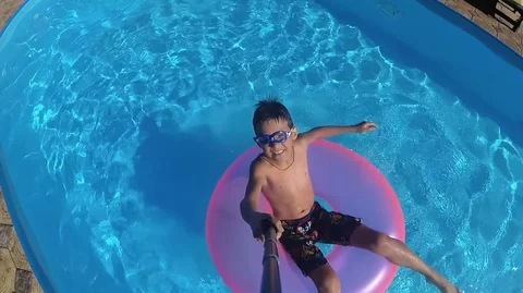 Boy floats on an inflatable circle in the pool Stock Footage 82145830