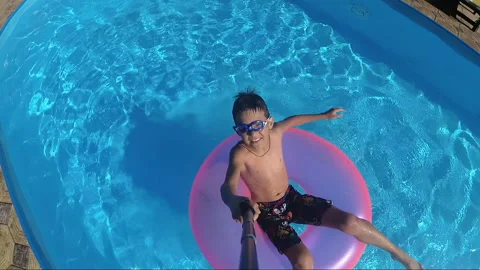 Boy Floats On An Inflatable Circle In The Pool, outdoors Stock Footage 99063535