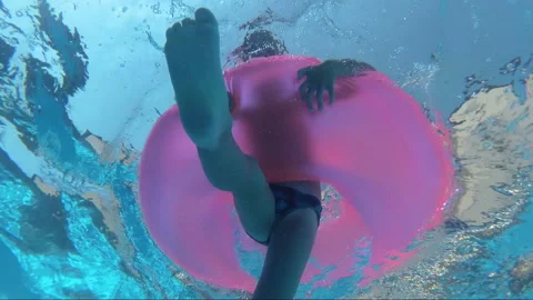 Boy floats on an inflatable circle in the pool, outdoors Stock Footage 99064895