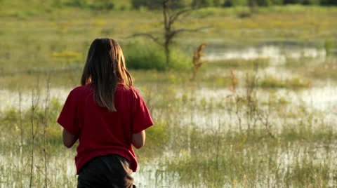 Boy on a flooded meadow, swamp boy explores Stock Footage 24892811
