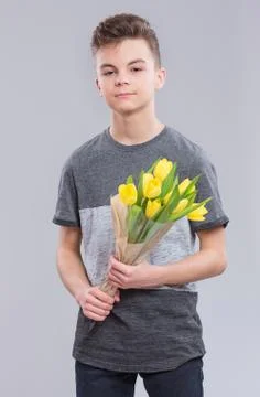 Boy with flowers on gray Stock Photos