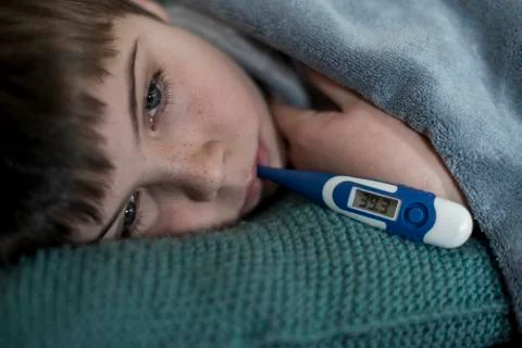 Boy with flu lying, close up portrait Photos