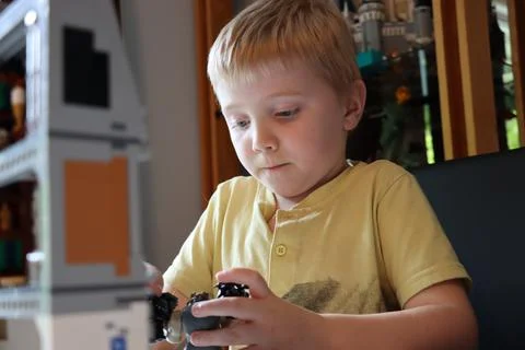 Boy focused on playing with lego Stock Photos