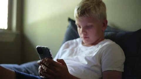 Boy focused on smart phone Vídeos de archivo 135691718
