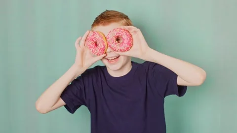 The boy fools around with donuts Stock Footage 232810201