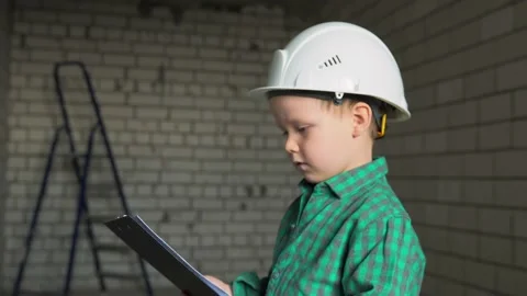 The boy is a foreman indoors at a construction site. Stock Footage 238477090