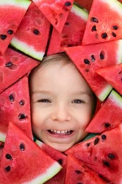 A boy framed by triangular pieces of watermelon.Cute portrait of a baby Stock Photos