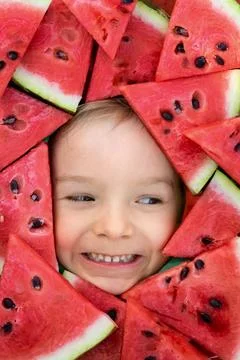 A boy framed by triangular pieces of watermelon.Cute portrait of a baby Fotos Stock