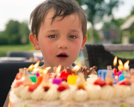 Boy in front of birthday cake Stock Photos