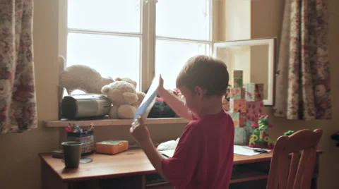 BOY IN FRONT OF THE DESK MAKING PARTY INVITATIONS Stock Footage 68755646