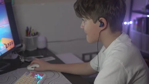 A boy gambler plays a computer game at home in the evening Stock Footage 305650857