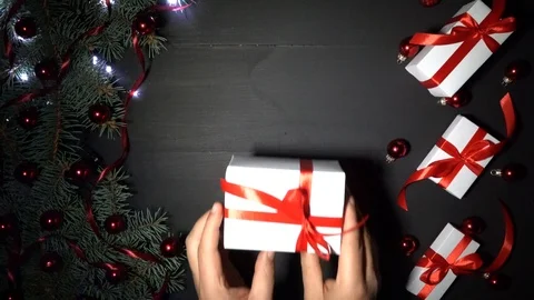 A boy gave him a gift on the table adorned with fir branches, gifts and lights Stock Footage 99062464