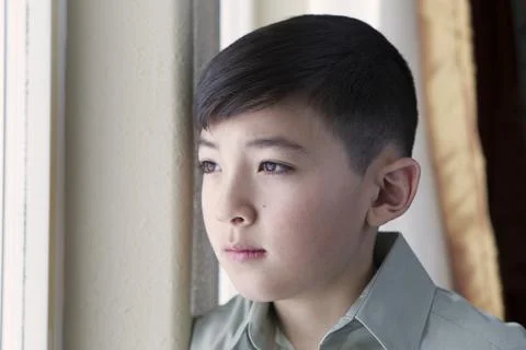 Boy gazes out the window. Stock Photos