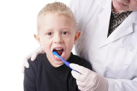 Boy gets help by the Dentist to brush his teeth Stock Photos