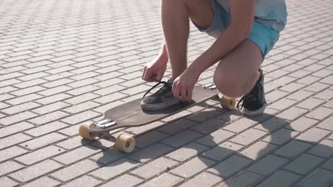 Boy Gets Ready to Ride Skateboard Stock Footage