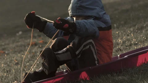 Boy gets ready to sled down a hill with no snow Video stock 158903297