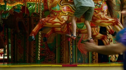 A boy is getting off the carousel at the Amusement Park in UK Stockbeeldmateriaal 111360458