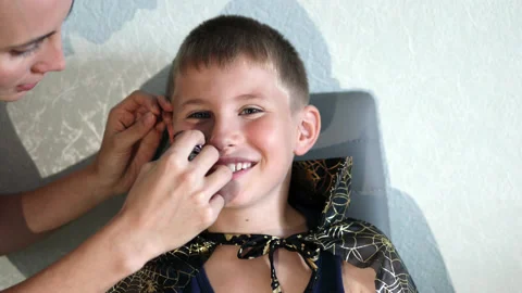 Boy getting his face painted for Halloween party. Copy space Stock Footage 158803737