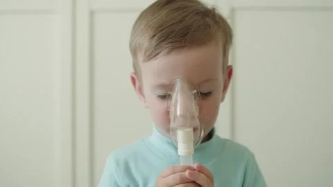 Boy getting respiratory treatment through a nebulizer mask. Stock-Footage 334848679