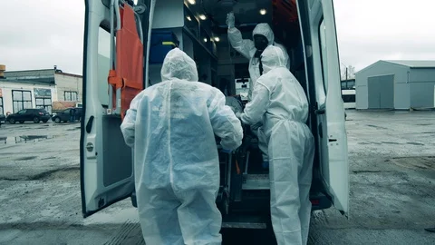 A boy is getting transported out of the ambulance by the paramedics Stock Footage 129522661