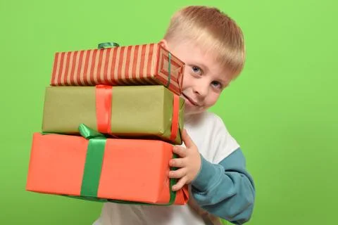 Boy with gift boxes on green background. Christmas concept Stock Photos
