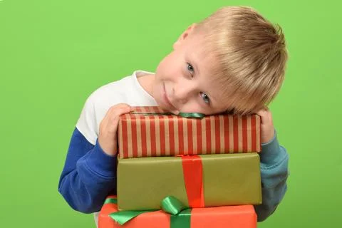 Boy with gift boxes on green background. Christmas concept Foto stock