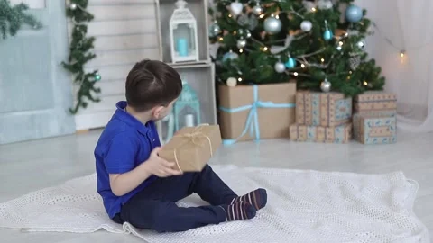 A boy with a gift under the Christmas tree. Festive mood. A gift for the new Stock Footage 165238057