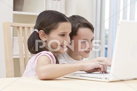Boy & girl children using laptop computer at home Stock Photos