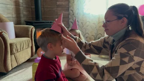 The boy is given a festive hat to celebrate his birthday Stock Footage 293585538