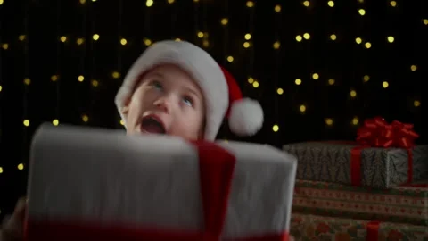 A boy is given a gift at Christmas, and he enjoys catching it. Video stock 295390937