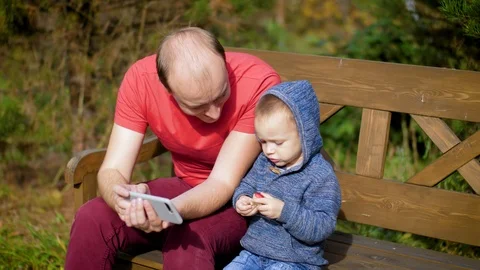 The boy gives the man a bite wound. Son plays Apple with father. A man with a Stock Footage 97637422