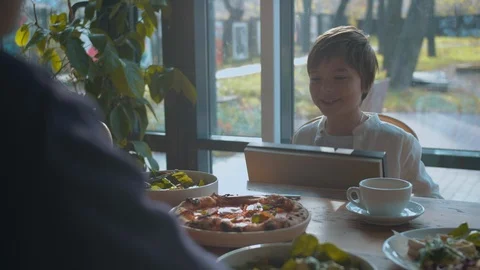 Boy gives a present to his father in a cafe Stock Footage 120736028