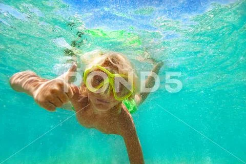 Boy giving thumb up while swimming underwater Stock Photos