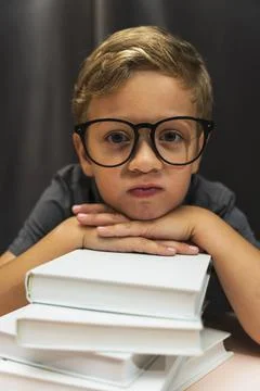 A boy with glasses and a stack of books, back to school, study fatigue, study Stock Photos
