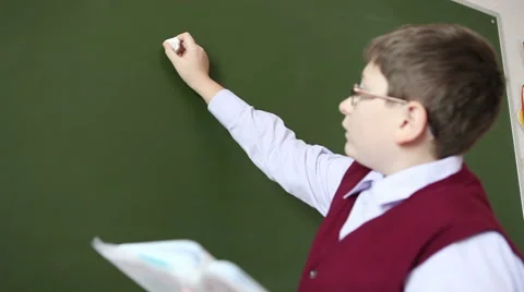 Boy with glasses decides to sample at the blackboard Stock Footage 58866990