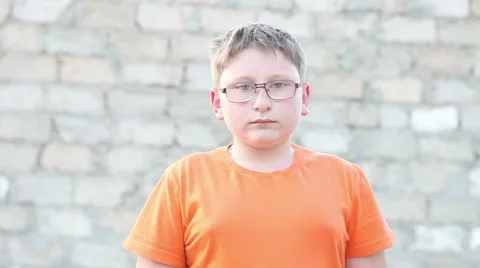 Boy with glasses looking at the camera. Outdoors Stock Footage 63139905