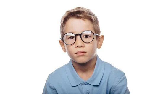 A boy with glasses looks thoughtfully at the camera, displaying curiosity abo Stock-Fotos