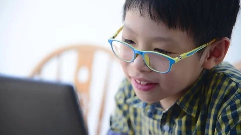 Boy with glasses playing games on computer. Stock Footage 69894972
