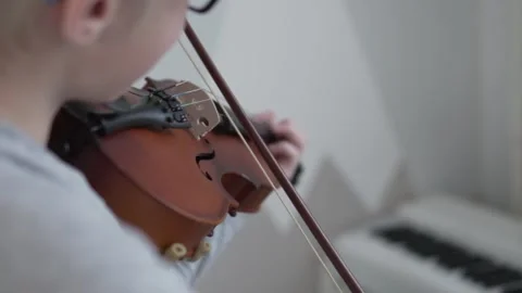A boy in glasses plays the violin, focus on the bow and musical instrument, the Stock Footage 145414213
