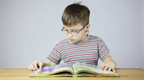 Boy with glasses reading a book Video stock 47413091