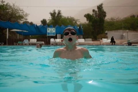 Boy with glasses swims in the pool Stock Photos