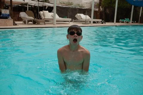 Boy with glasses swims in the pool Stock Photos
